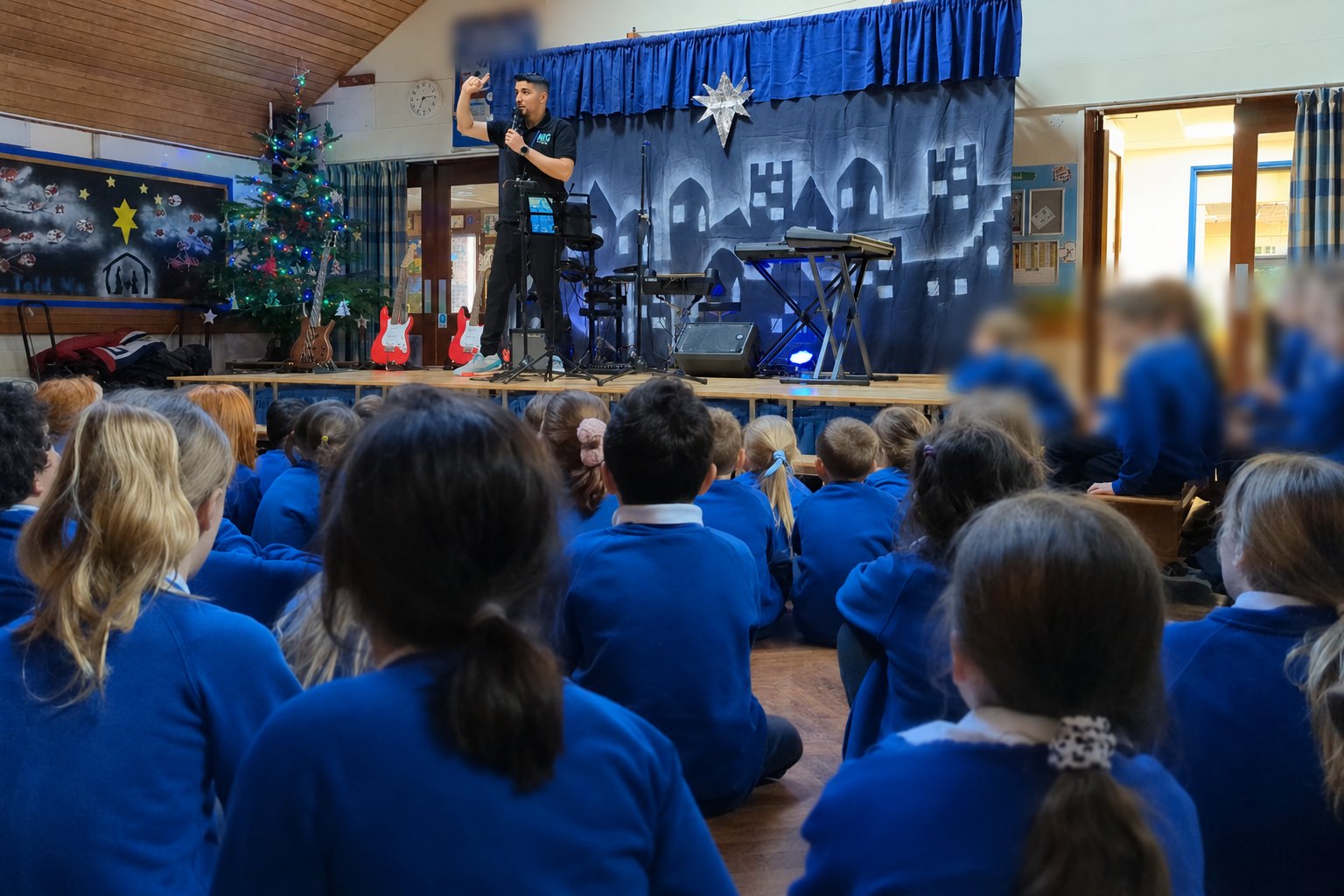 Ross Grillo leading a music assembly in a school